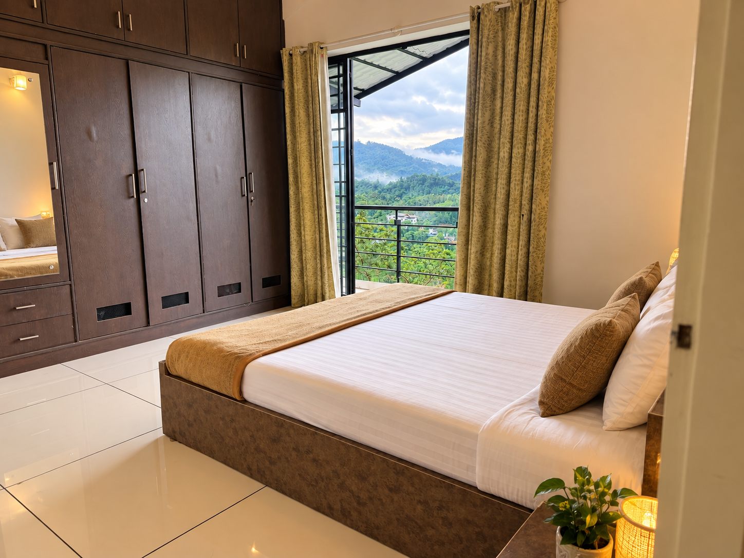A 2 BHK bedroom with wardrobe storage and a balcony looking out to misty Wayanad hills